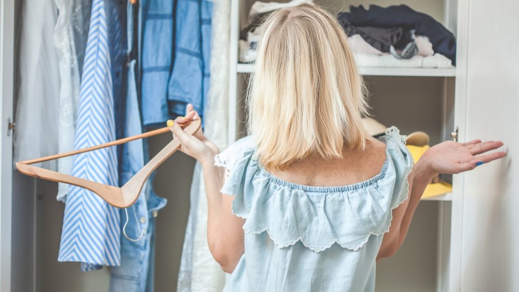 Woman standing in front of a messy wardrobe